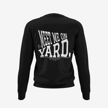 Load image into Gallery viewer, A black long-sleeve crewneck sweatshirt shown from the back, featuring a large white graphic text print that reads 'MEET ME ON YARD.' 
